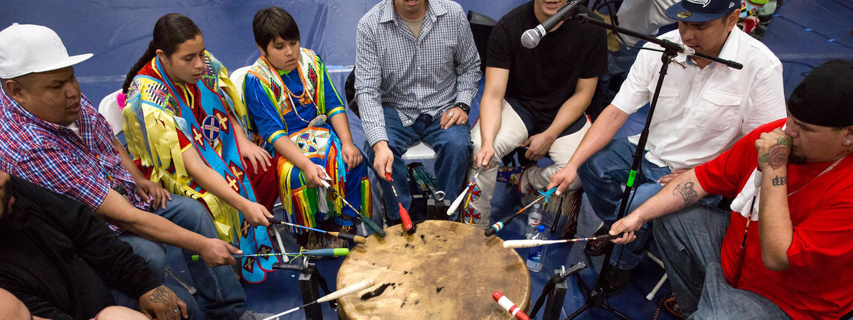 photo of a circle of drummers singing and drumming for the dancers during the 39th annual UC Berkeley Pow Wow 2018.